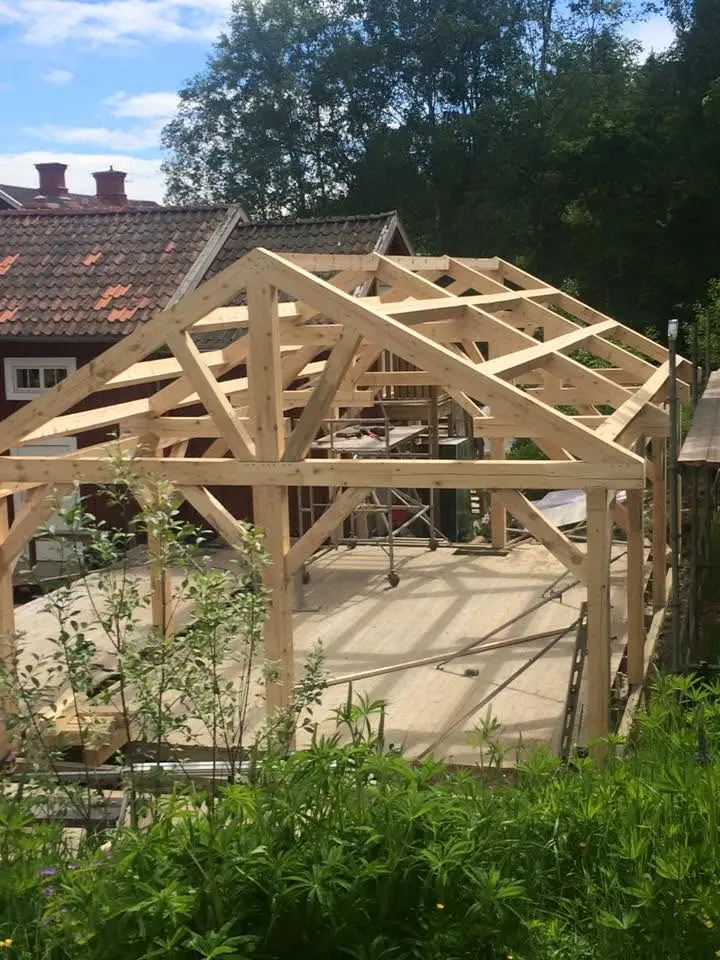 Tillbyggnad under arbete med synlig stomme och takstolar i trä.